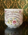 Stor antikk bartekopp i hvitt steingods/porselen rikt dekorert med blomstermotiv, tekst og gullkant Tyskland 1890-tallet thumbnail